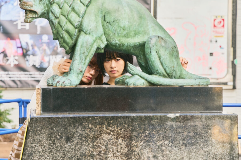 銅像の隙間から顔を覗かせる森七菜とアオイヤマダのツーショット